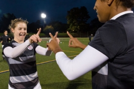 two soccer players point fingers at one another